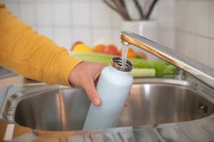someone filling up their metal water bottle