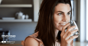 Brunette woman drinking clean Haferman Water from glass